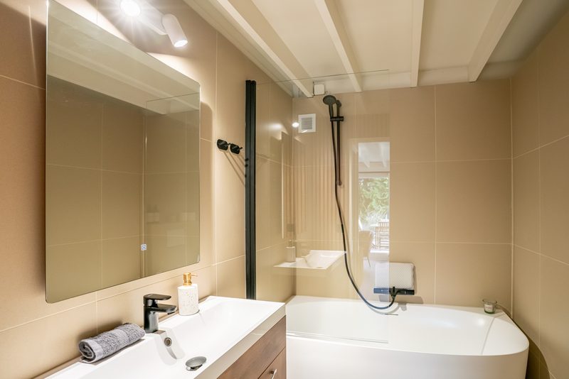 Badkamer met douche en vrijstaand bad