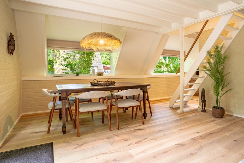 Eetruimte met houten balken en trap