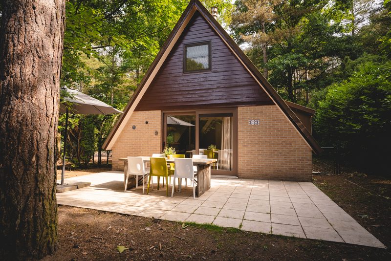 Woning met puntgevel en terras tussen bomen