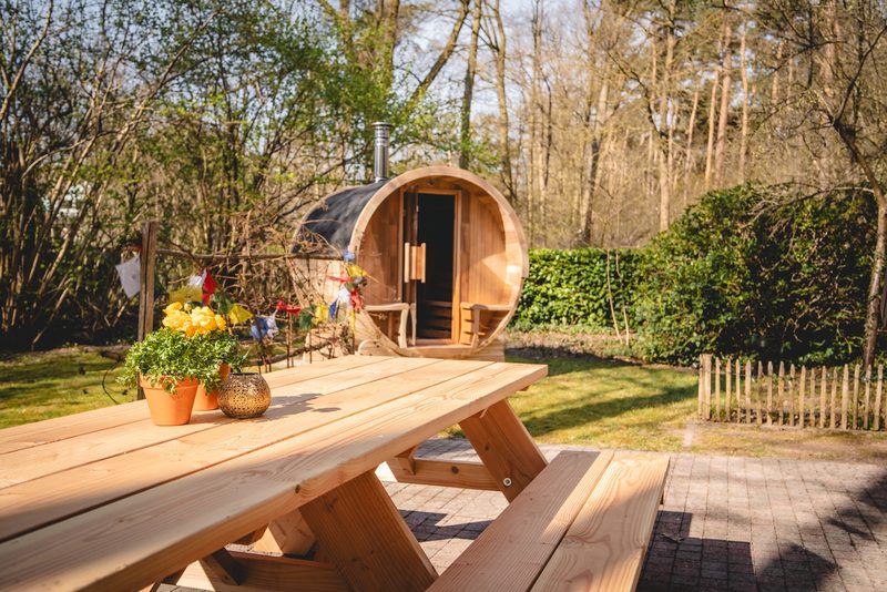 Buitenterras met houten tafel tussen groen