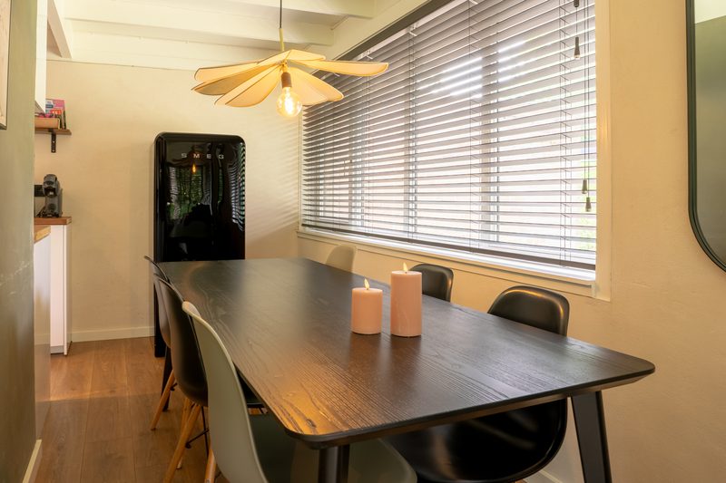 Keuken met donker werkblad en houten eettafel